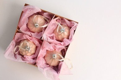 Photo of Beautiful Christmas baubles in box on white background, top view. Space for text