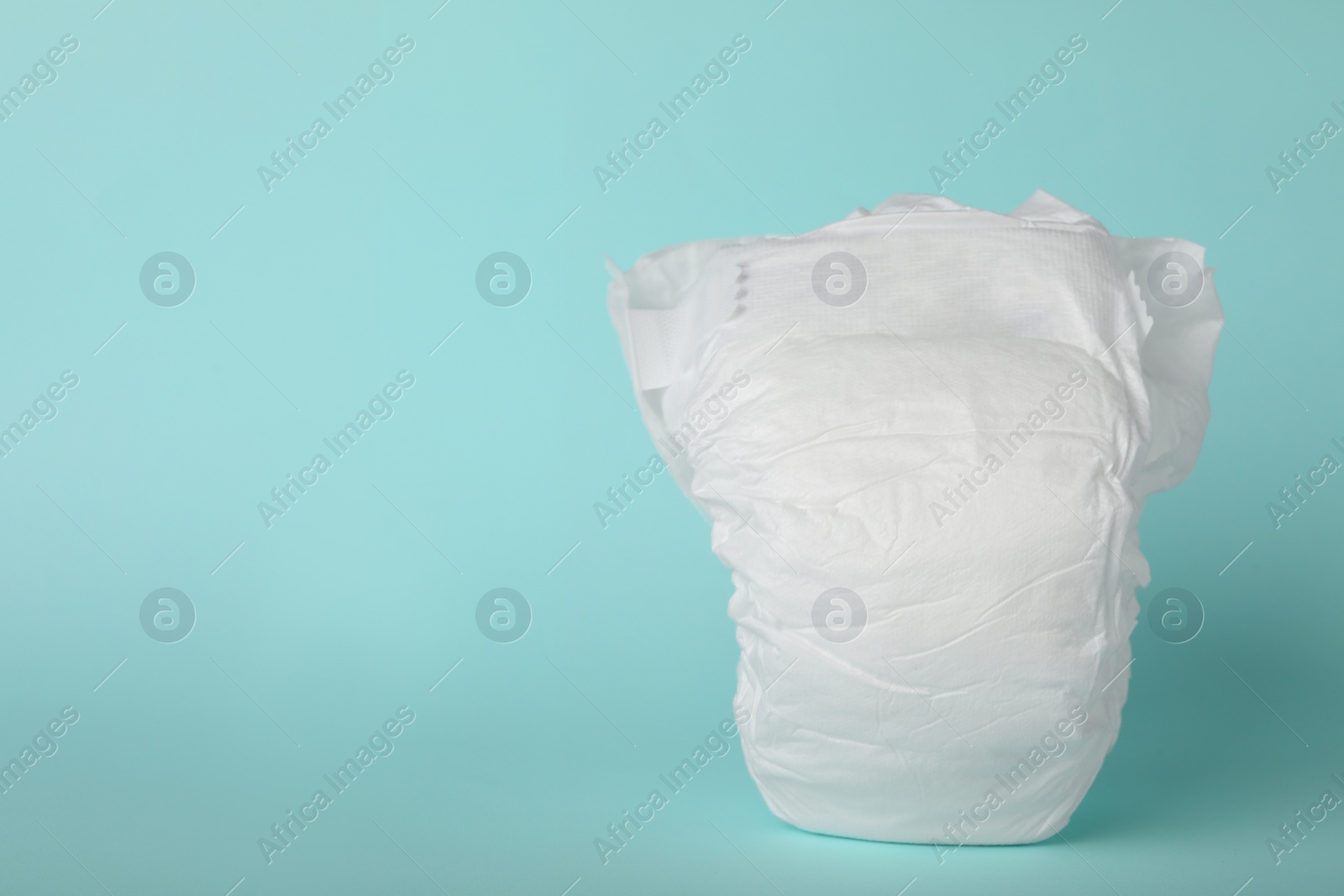 Photo of Baby diaper on light blue background. Space for text