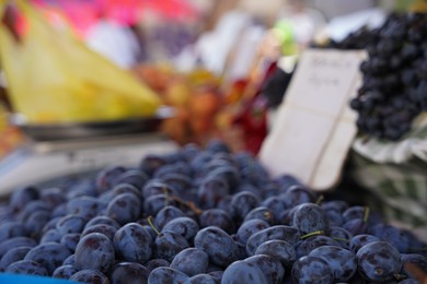 Photo of Heap of fresh ripe plums at market, closeup