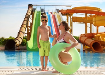 Photo of Son and mother with inflatable ring near pool in water park. Family vacation