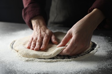 Photo of Woman kneading pizza dough at table, closeup