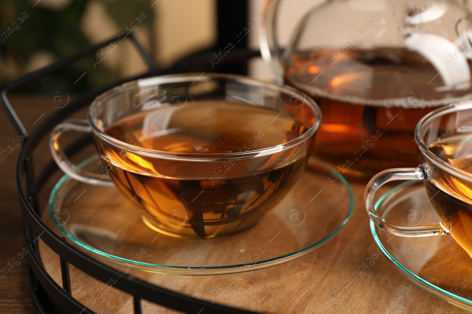 Photo of Aromatic tea in glass cups on wooden table, closeup