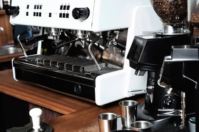 Photo of Modern coffee machine on bar counter in cafe