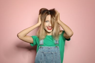 Beautiful young woman with healthy long blonde hair on color background