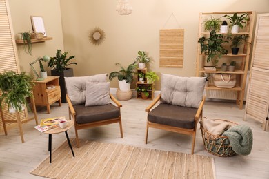 Photo of Lounge area interior with comfortable armchairs and beautiful houseplants