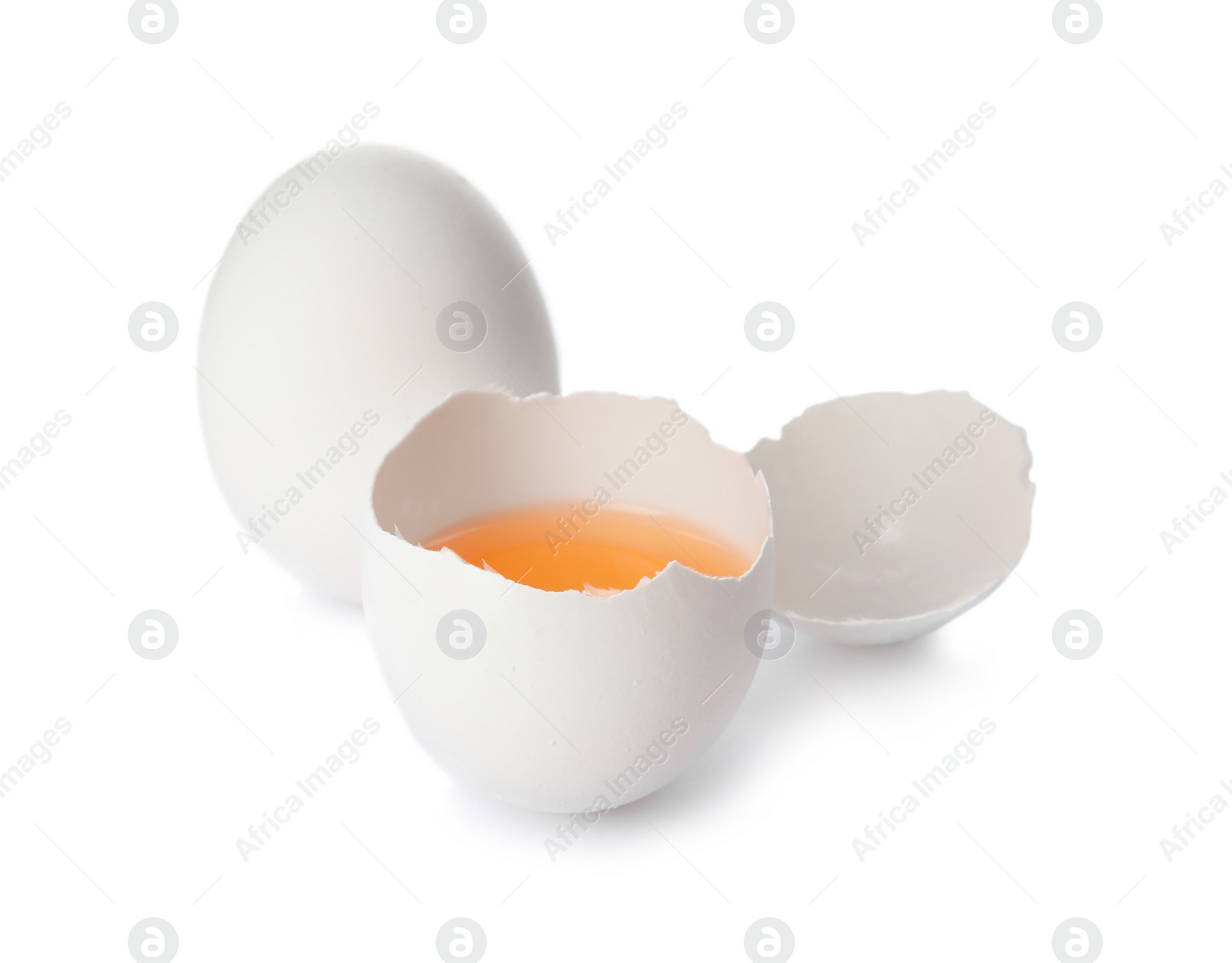 Photo of Cracked and whole chicken eggs on white background