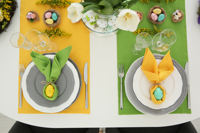 Festive Easter table setting with beautiful tulips and eggs, above view