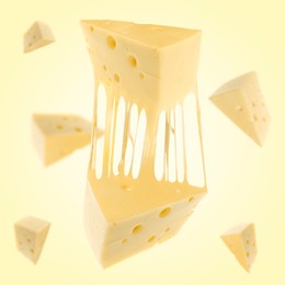 Image of Pieces of cheese falling on yellow background