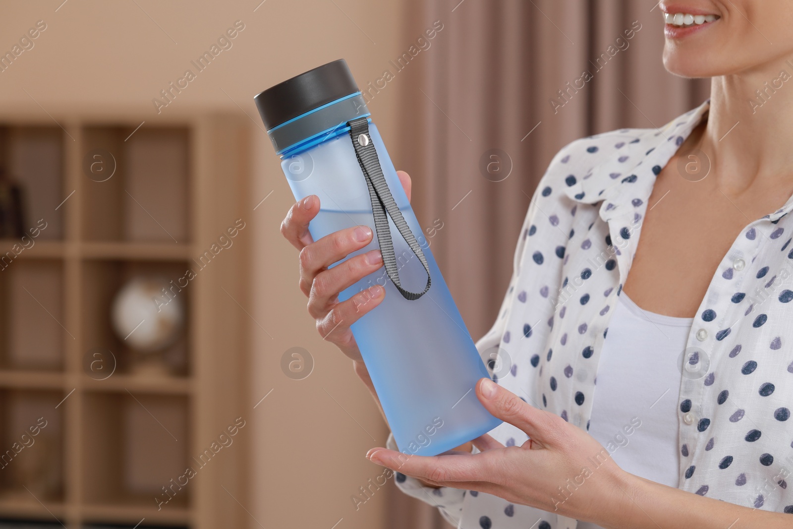 Photo of Woman with bottle of water in room, closeup. Space for text