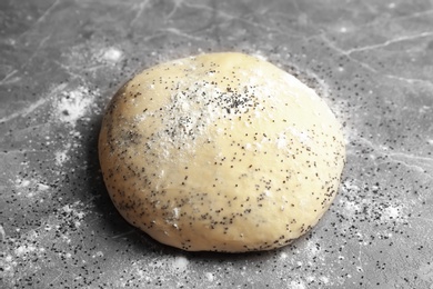 Photo of Raw dough with poppy seeds on table