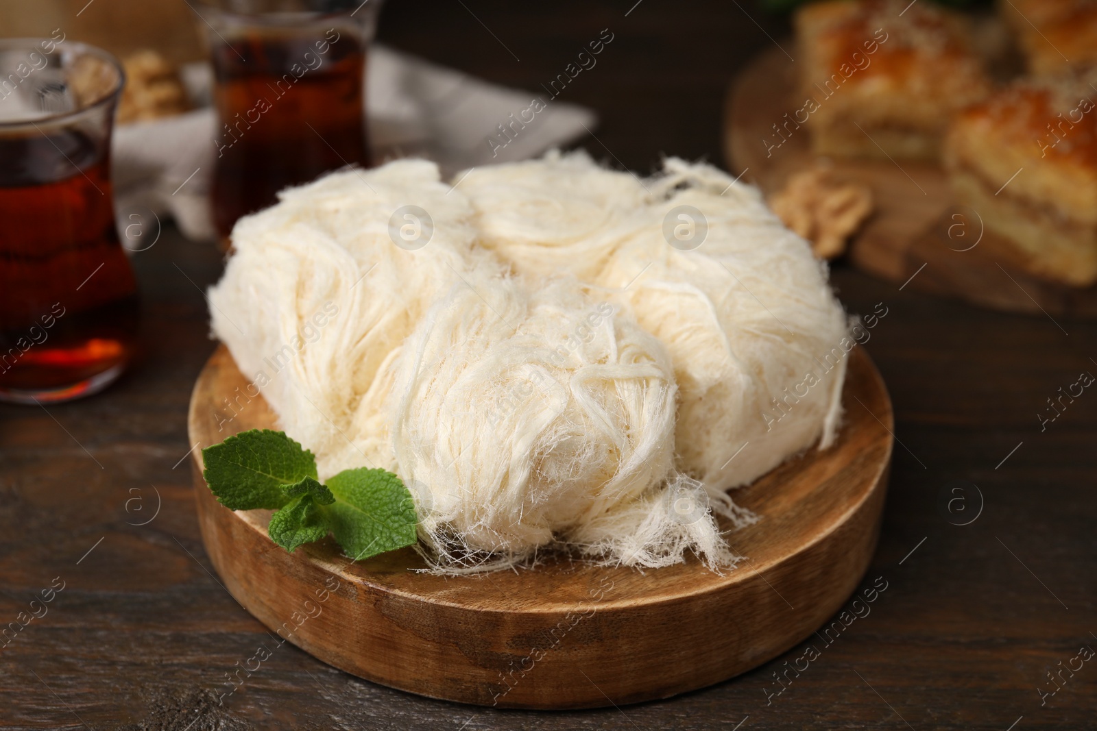 Photo of Eastern sweets. Tasty Iranian pashmak on wooden table, closeup