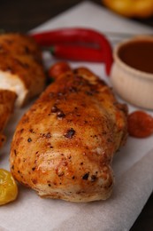 Photo of Baked chicken fillets and marinade on table, closeup