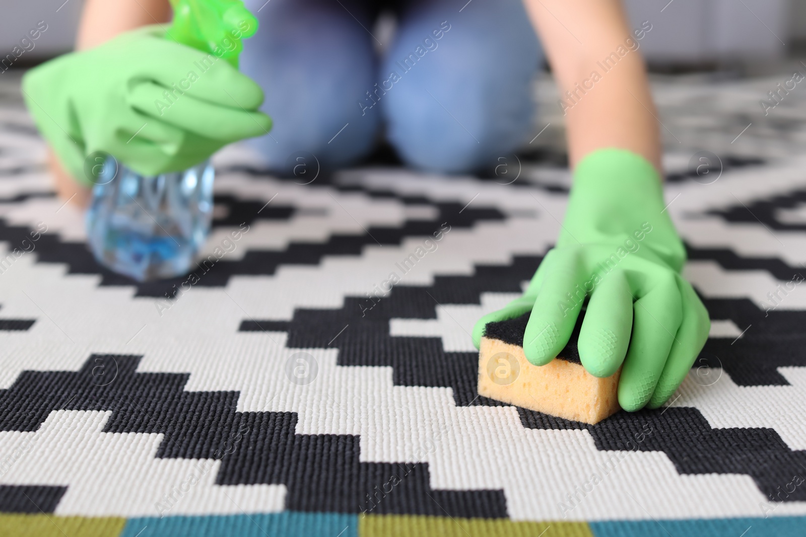 Photo of Woman cleaning carpet in living room