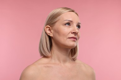 Beautiful woman with healthy skin on pink background