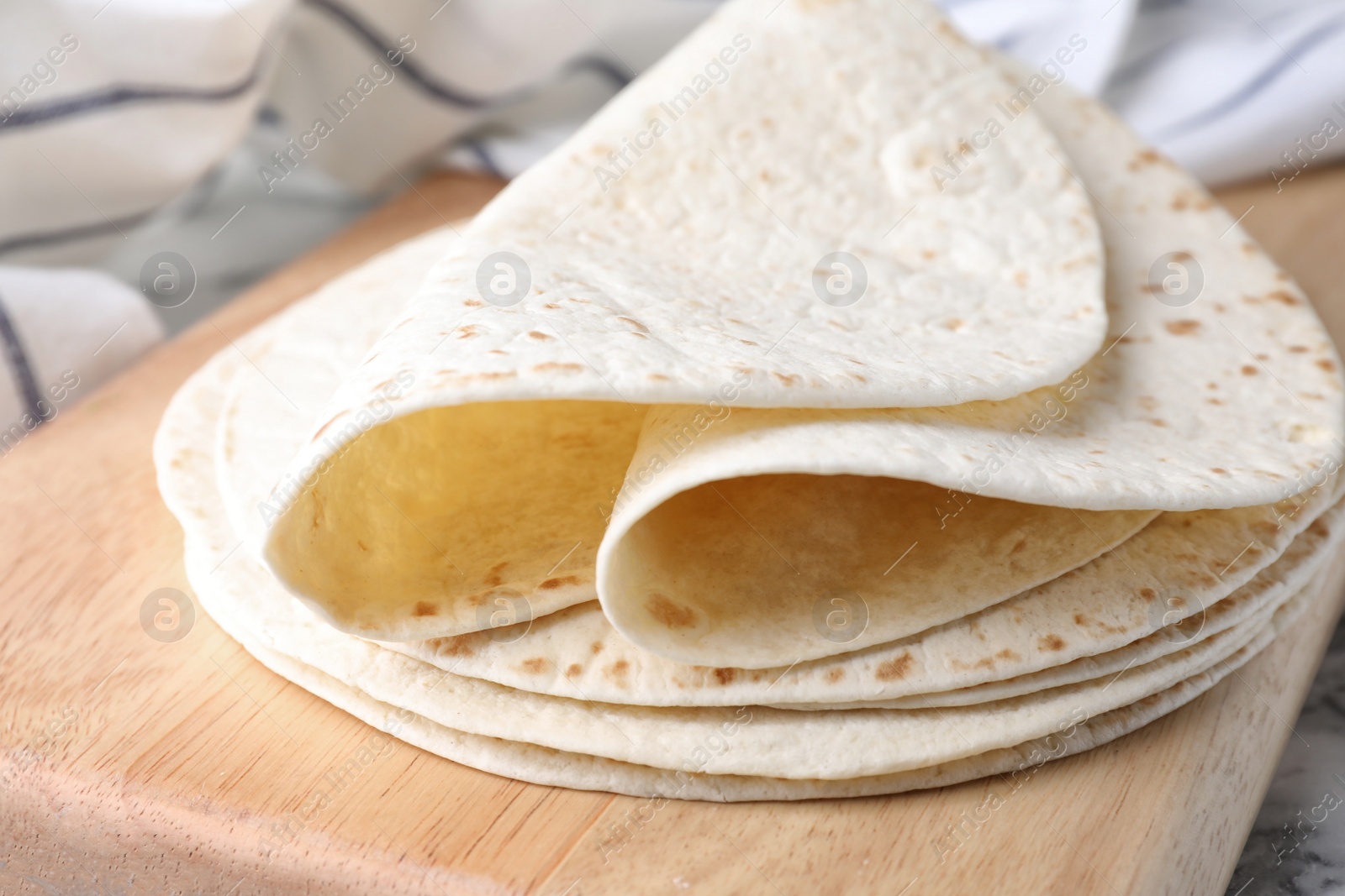 Photo of Wooden board with corn tortillas, closeup. Unleavened bread