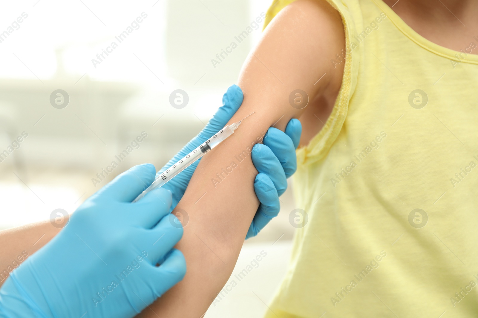 Photo of Doctor vaccinating little child in clinic, closeup