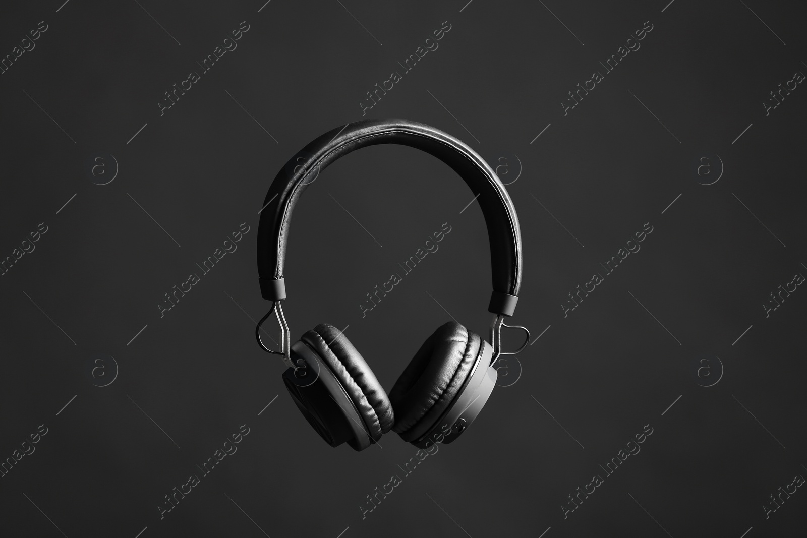 Photo of Stylish headphones with pads on black background