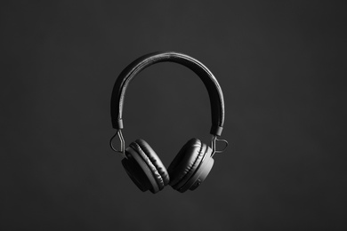 Photo of Stylish headphones with pads on black background