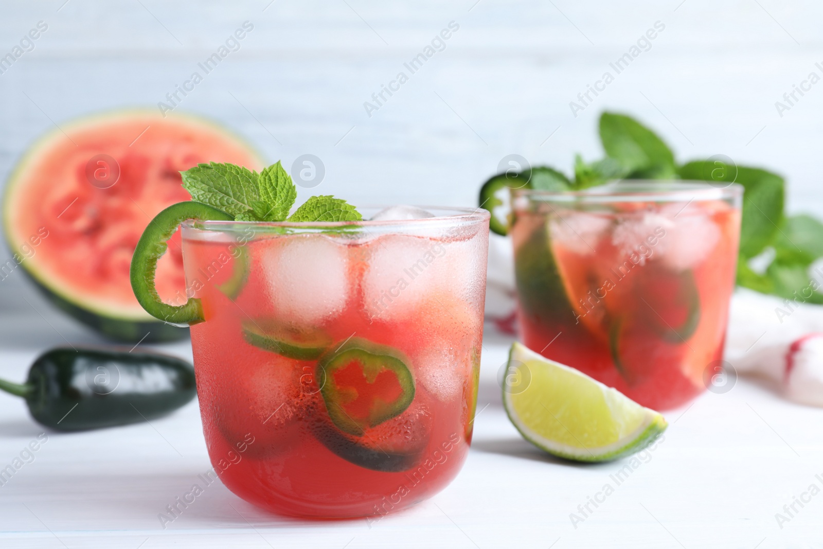 Photo of Spicy cocktail with jalapeno and mint on white table. Space for text