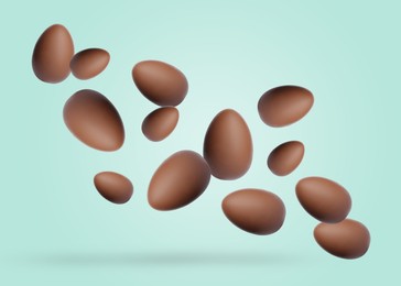 Image of Many chocolate eggs falling on pale mint color background