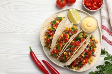 Tasty tacos with vegetables on white wooden table, flat lay. Space for text