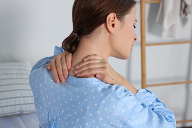 Photo of Woman suffering from neck pain in room