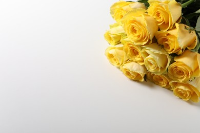 Beautiful bouquet of yellow roses on white background, above view. Space for text