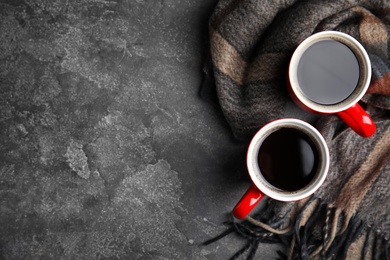 Photo of Flat lay composition cups of hot coffee and blanket on grey stone background, space for text. Winter drink