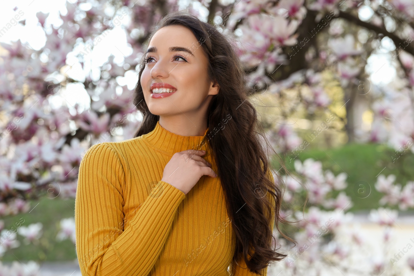 Photo of Beautiful woman near blossoming magnolia tree on spring day