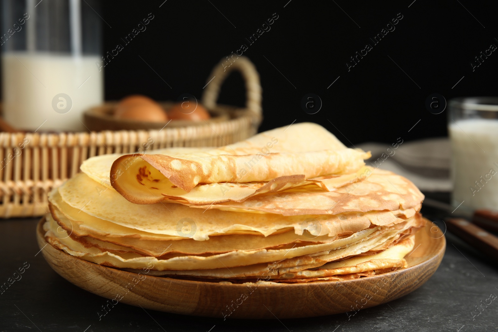 Photo of Stack of fresh thin pancakes on black table