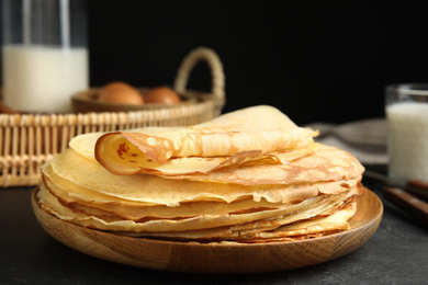 Photo of Stack of fresh thin pancakes on black table