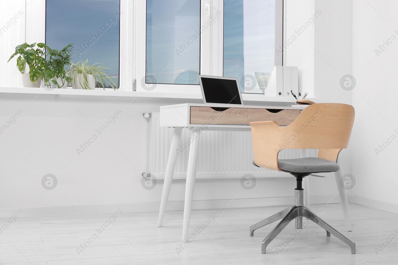 Photo of Comfortable workplace near window in stylish room. Home office