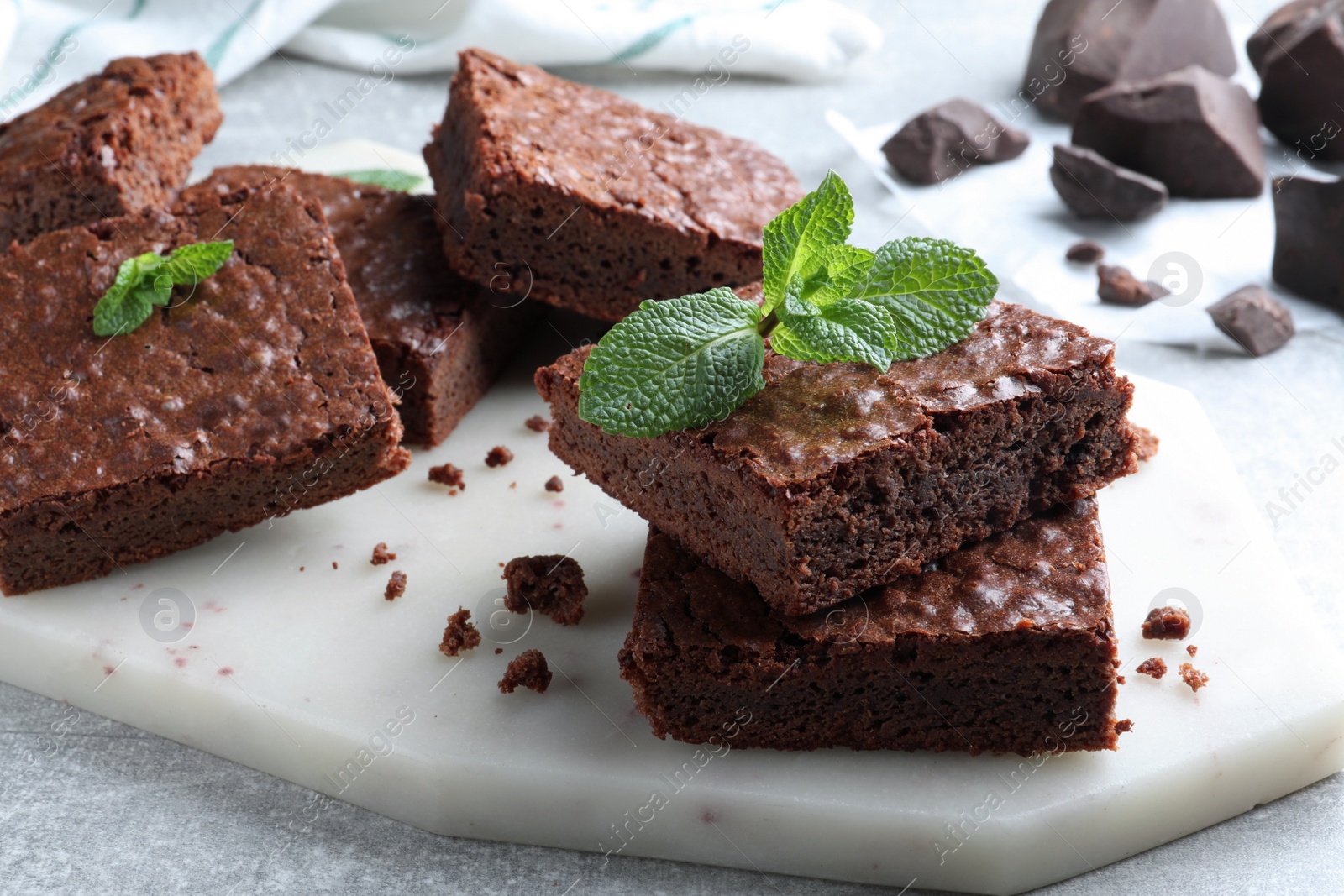 Photo of Delicious chocolate brownies with fresh mint on grey table