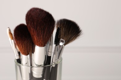 Set of professional makeup brushes on white background, closeup. Space for text