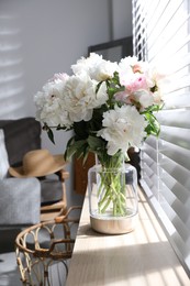 Photo of Bouquet of beautiful peony flowers on window sill indoors