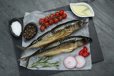 Delicious smoked mackerels and products on gray table, top view
