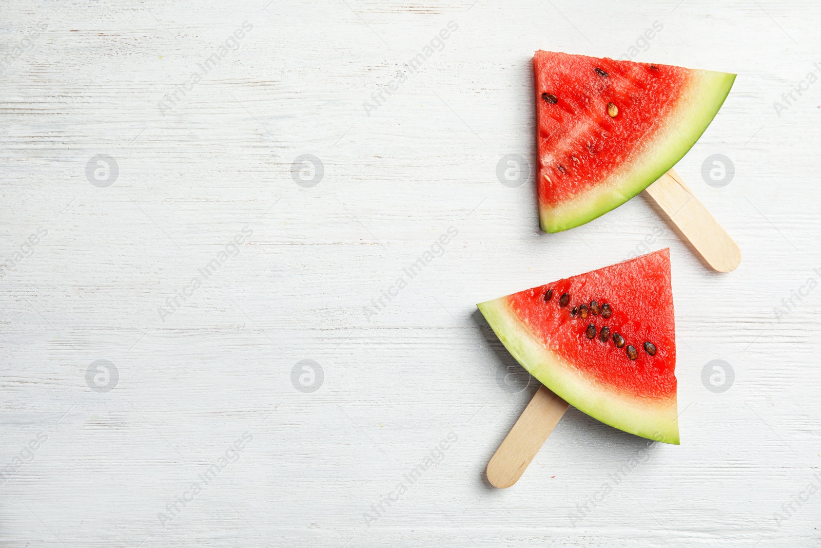 Photo of Watermelon popsicles on wooden background, top view