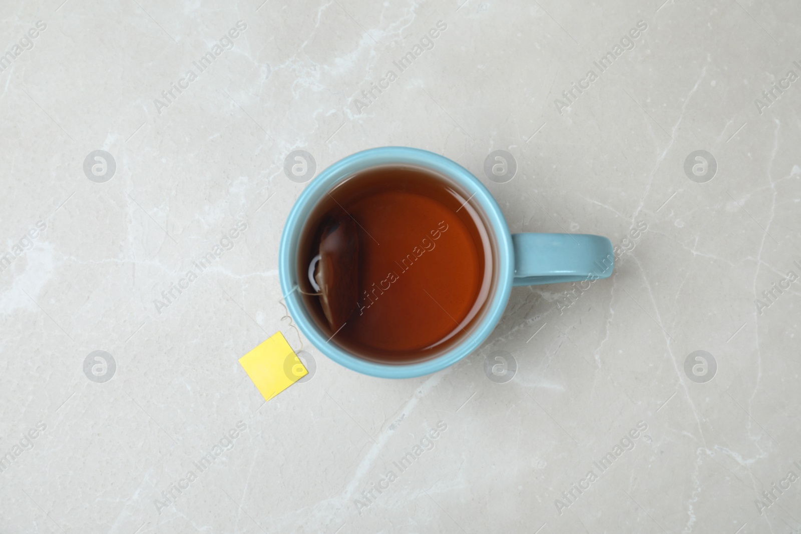 Photo of Cup of delicious hot tea on grey background, top view