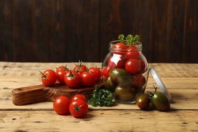 Photo of Pickling jar with fresh cherry tomatoes on wooden table