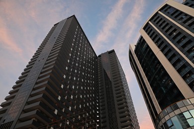 Beautiful skyscrapers on city street in evening, low angle view