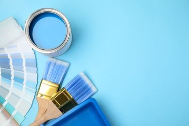 Flat lay composition with can of paint, brush and renovation tools on blue background, space for text