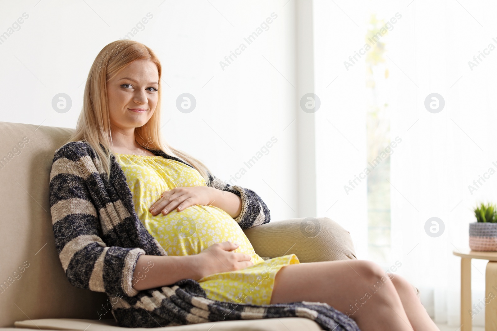 Photo of Beautiful pregnant woman resting on sofa at home