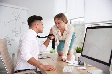 Colleagues flirting with each other during work in office