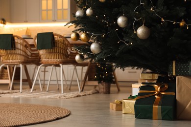 Beautifully decorated Christmas tree and gift boxes in spacious kitchen. Interior design