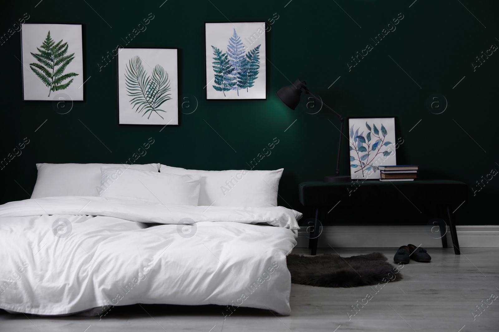 Photo of Comfortable bed with stylish white linens near green wall indoors