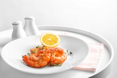 Plate with delicious fried shrimps and lemon on table