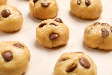 Photo of Unbaked chocolate chip cookies on white table, closeup