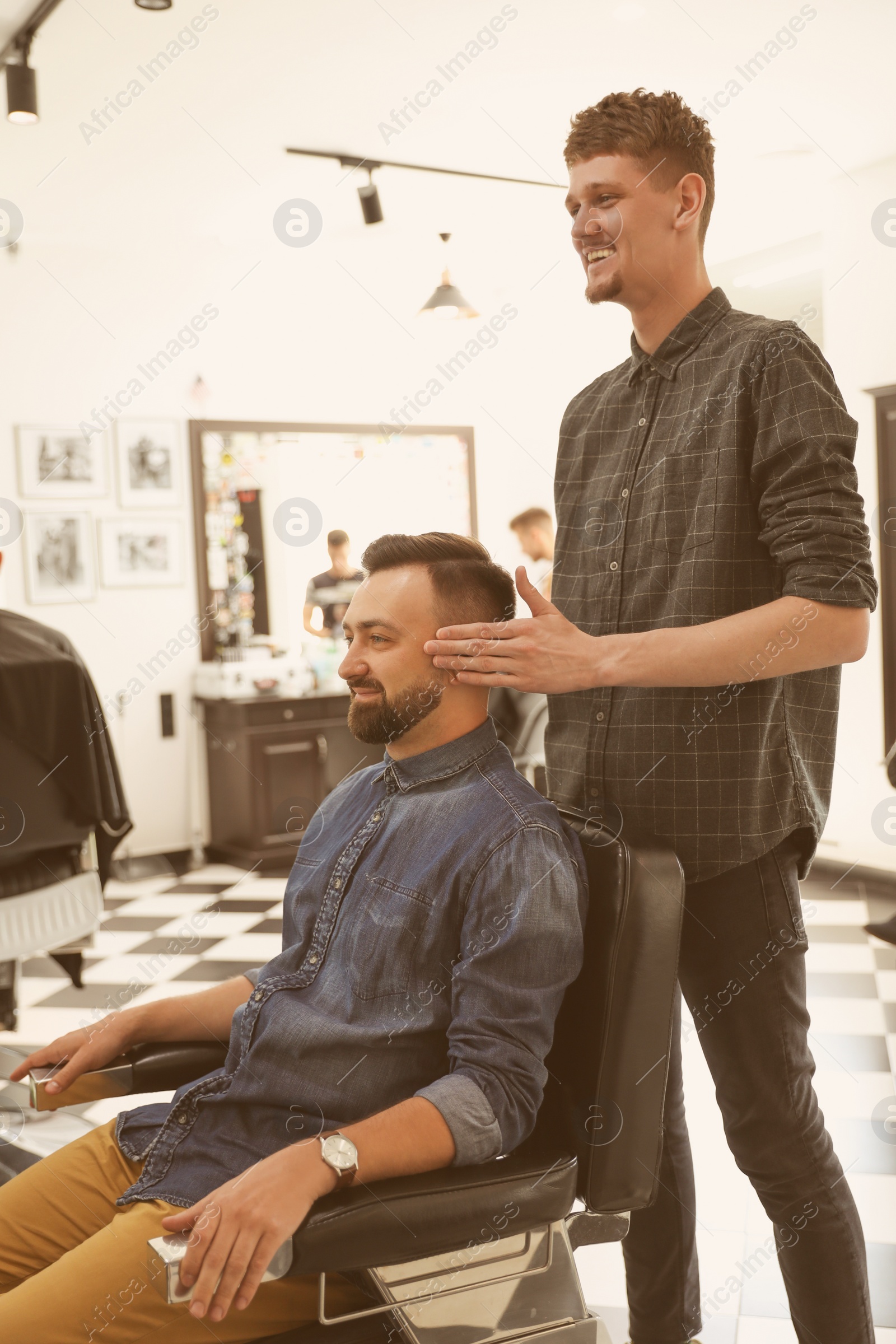 Photo of Professional barber working with client in hairdressing salon. Hipster fashion