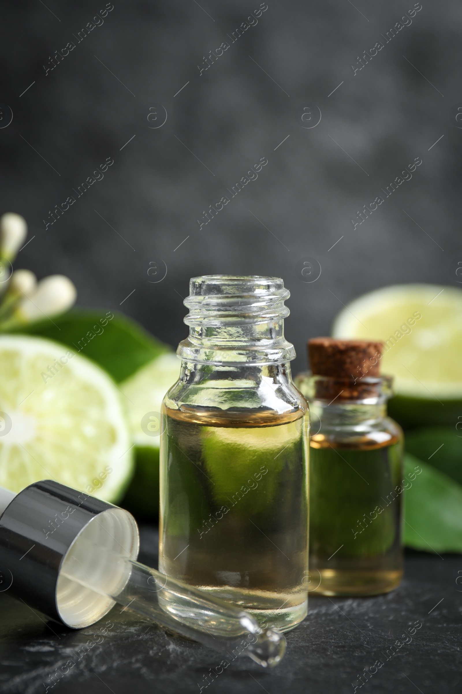 Photo of Bottles of citrus essential oil on black table