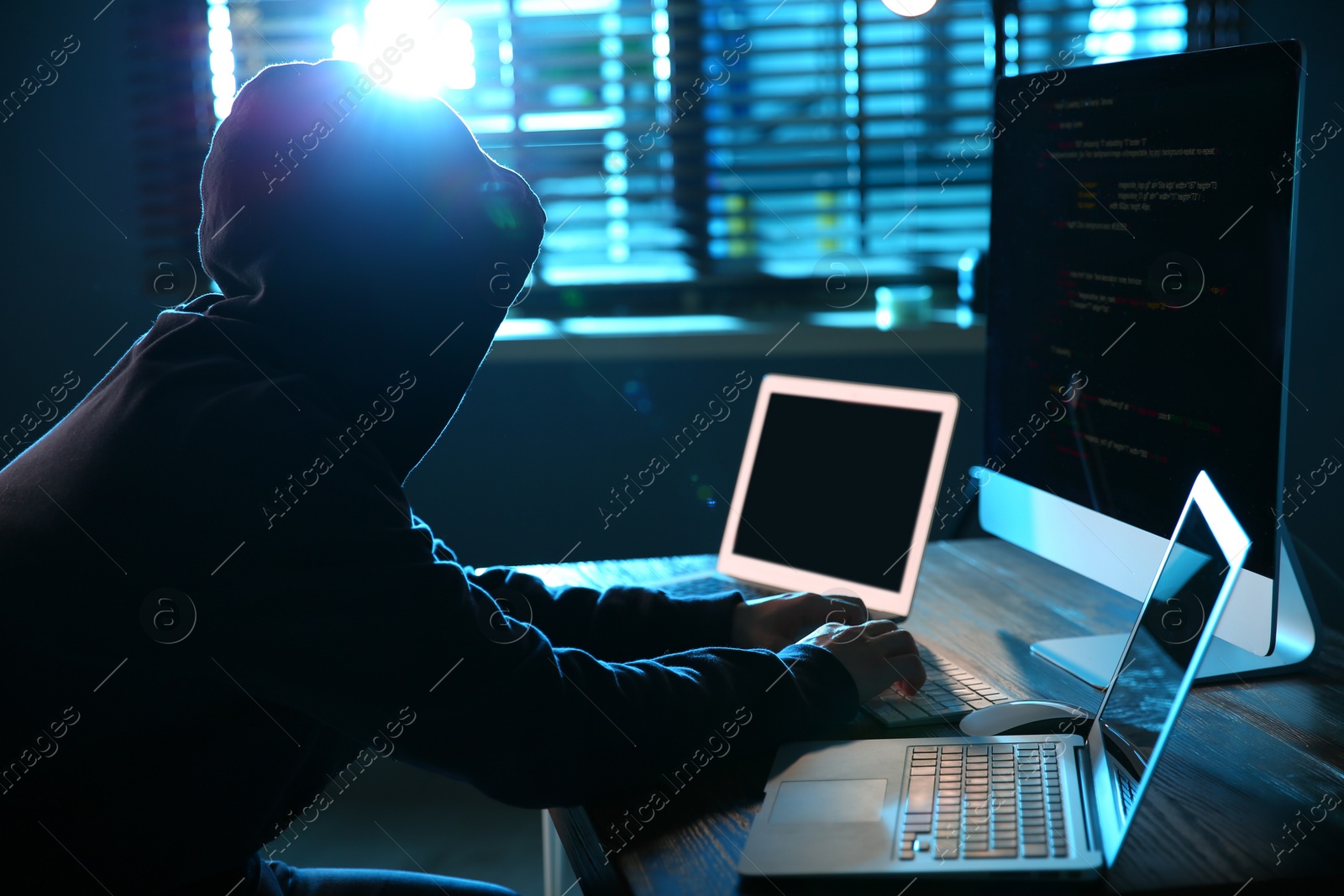 Photo of Hacker with computers in dark room. Cyber crime